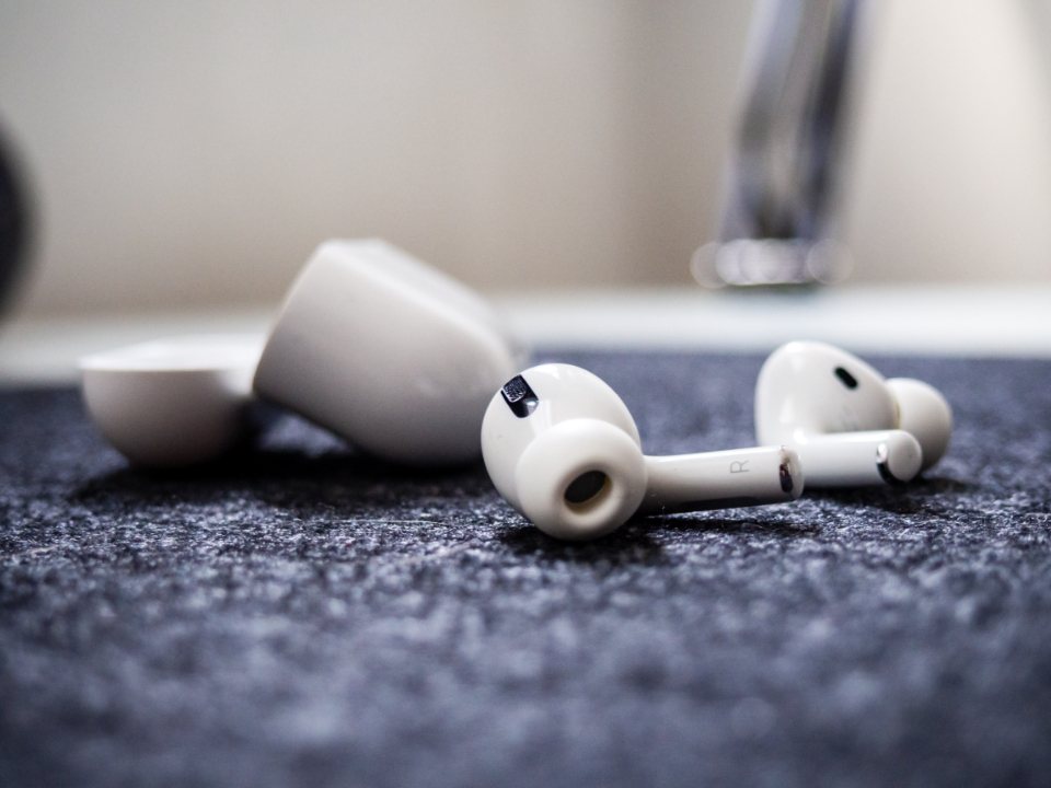 Wireless earbuds resting on a dark textured surface