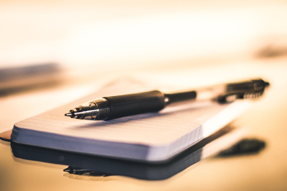 Fountain pen resting on an open notebook in warm light