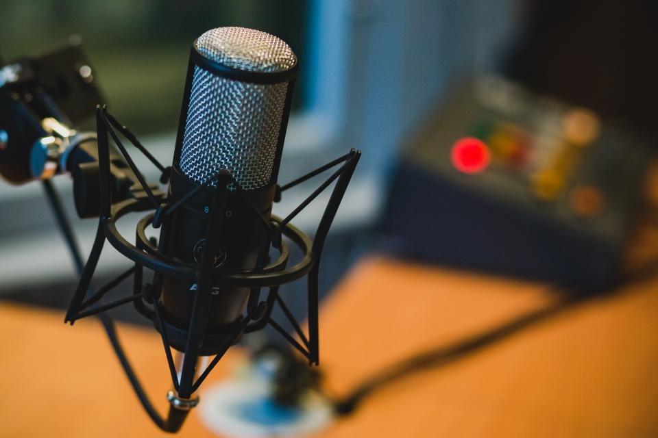 Condenser microphone on a shock mount on a studio desk in warm light